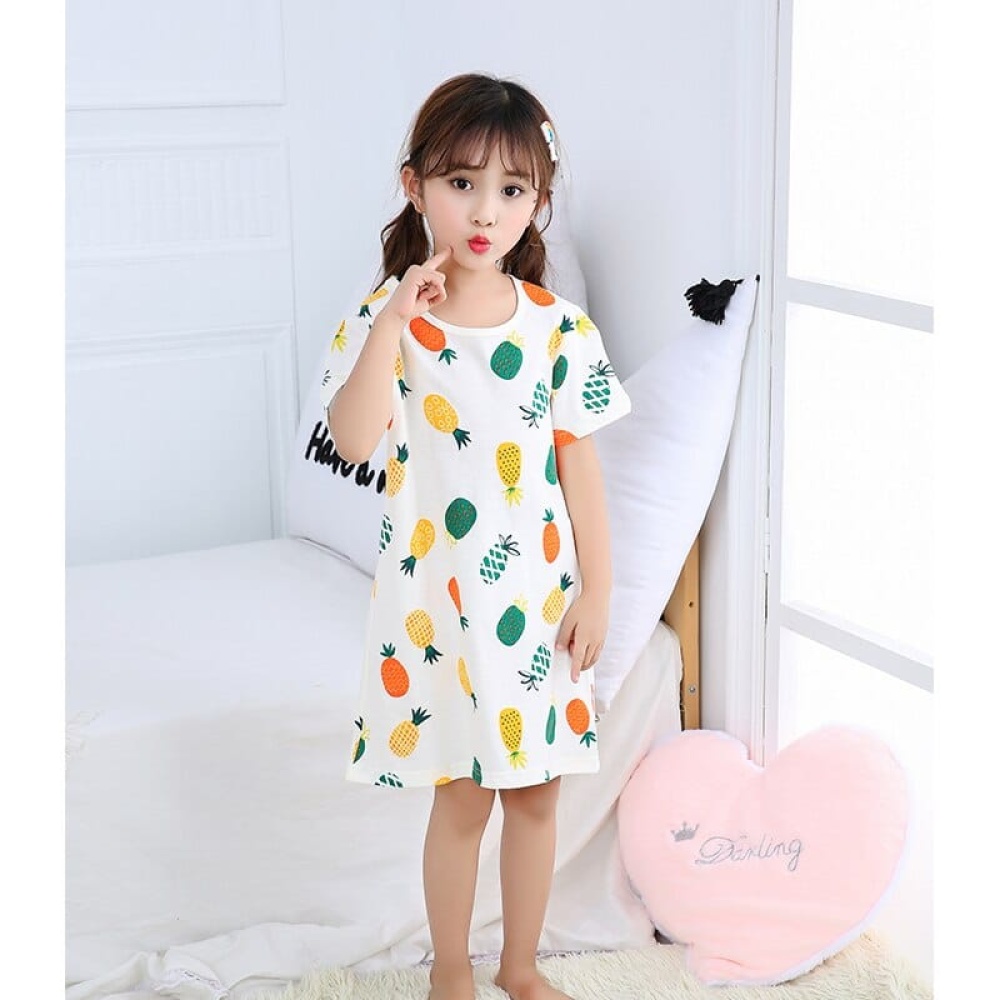 Pyjama-Nachtkleid mit kurzen Ärmeln und Ananasmuster für Mädchen, das von einem kleinen Mädchen in einem Haus getragen wird