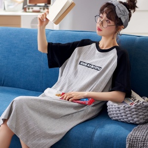 Sommerpyjama graues Baumwollnachtkleid für Frauen, getragen von einer Frau, die auf einem Sofa in einem Haus sitzt