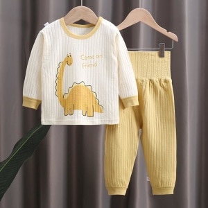 Pyjama-Set aus Baumwolle mit Dinosaurier-Motiv in braun und weiß auf einem Gürtel in einem Haus