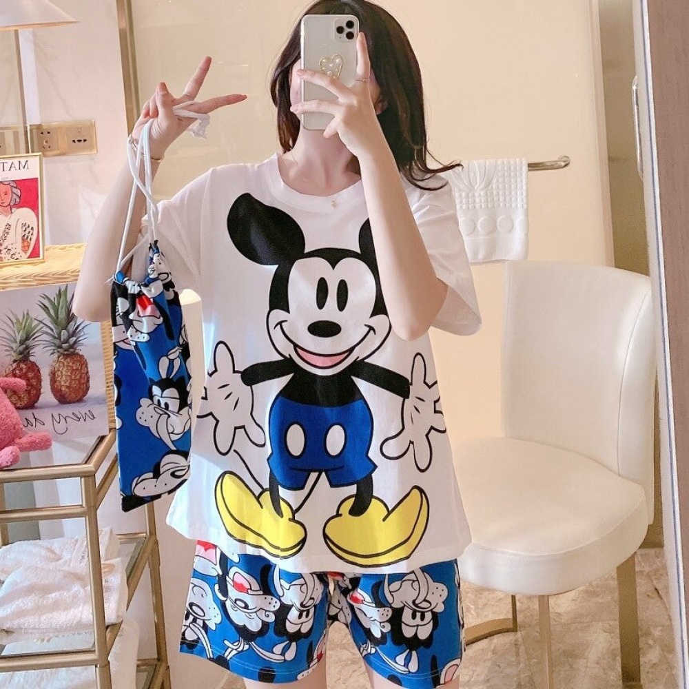 Sommer-Pyjama-Set aus Satin mit Mickey-Mouse-Print, getragen von einer Frau in einem Haus