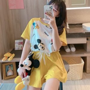 Gelber bedruckter Sommerpyjama Mickey Donald, der von einer Frau getragen wird, die einen Plüschtier trägt