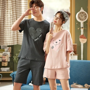 Pyjama, T-Shirt und Shorts aus Baumwolle mit der Aufschrift love me, getragen von einem sehr modischen Paar in einem Haus