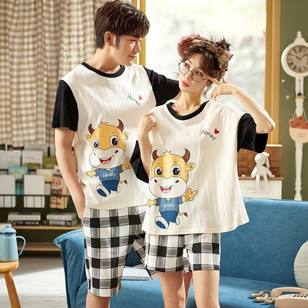 T-Shirt-Pyjama mit Stiermotiv und karierte Baumwollshorts, die von einem Paar vor einem Stuhl in einem Haus getragen werden
