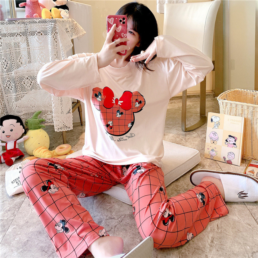 Zweiteiliger langärmeliger Baumwollpyjama mit Minnie-Mouse-Muster mit einem Mädchen, das den Pyjama trägt, und einem Hintergrund, der ein Zimmer mit Plüschtieren zeigt