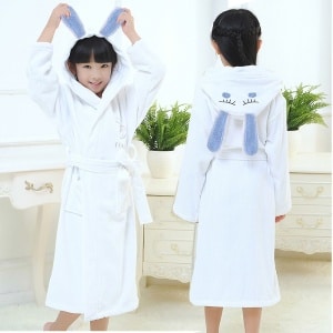 Weißer Kaninchenpyjama aus Baumwolle für Kinder in sehr hoher Qualität, getragen von einem kleinen Mädchen in einem Haus
