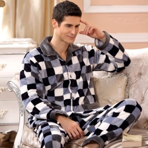 Damier-Pyjama aus Fleece für Männer, getragen von einem Mann, der auf einem Sofa in einem Haus sitzt