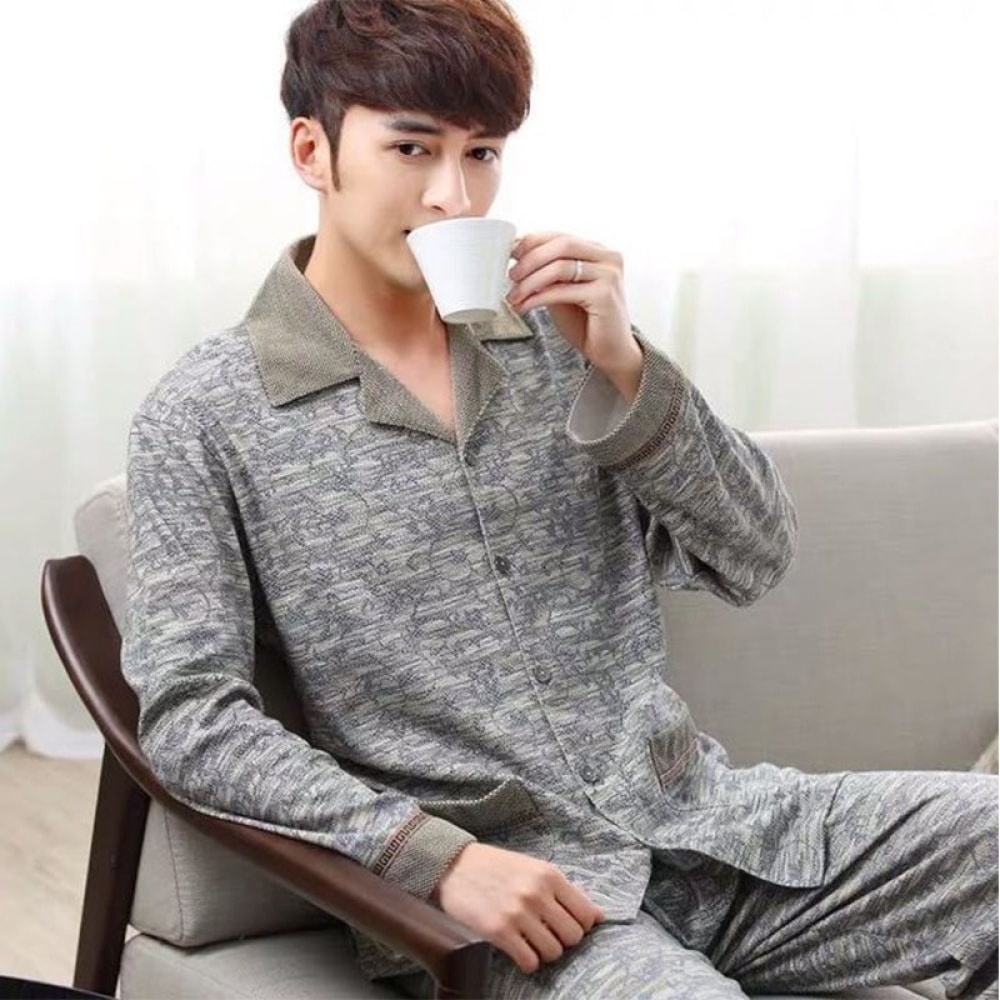 Khaki melierter Baumwollpyjama für Männer, der von einem Mann getragen wird, der in einem Haus Tee trinkt
