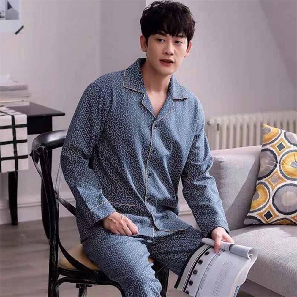 Pyjama mit modischem Baumwollmuster, getragen von einem Mann, der auf einem Stuhl in einem Haus sitzt