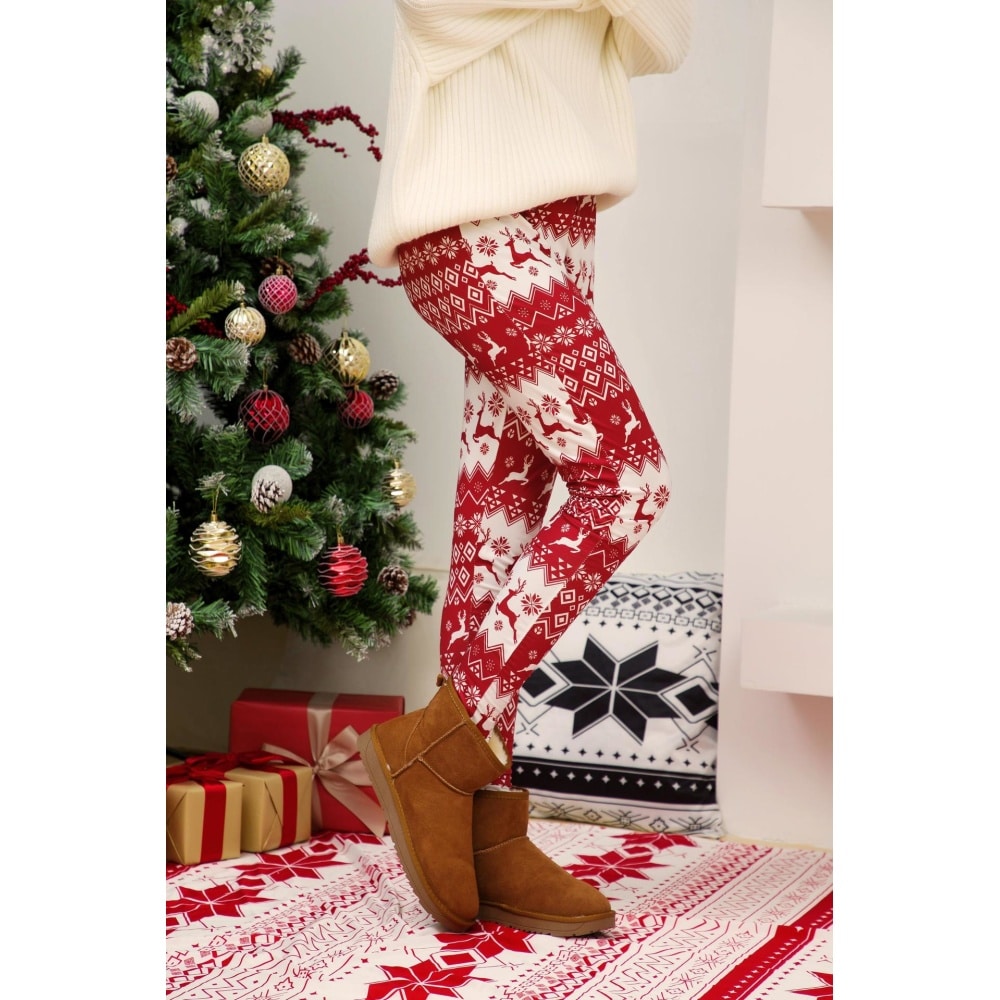 Weiße und rote weihnachtlich bedruckte Leggings für Frauen von einer Frau in einem Haus getragen