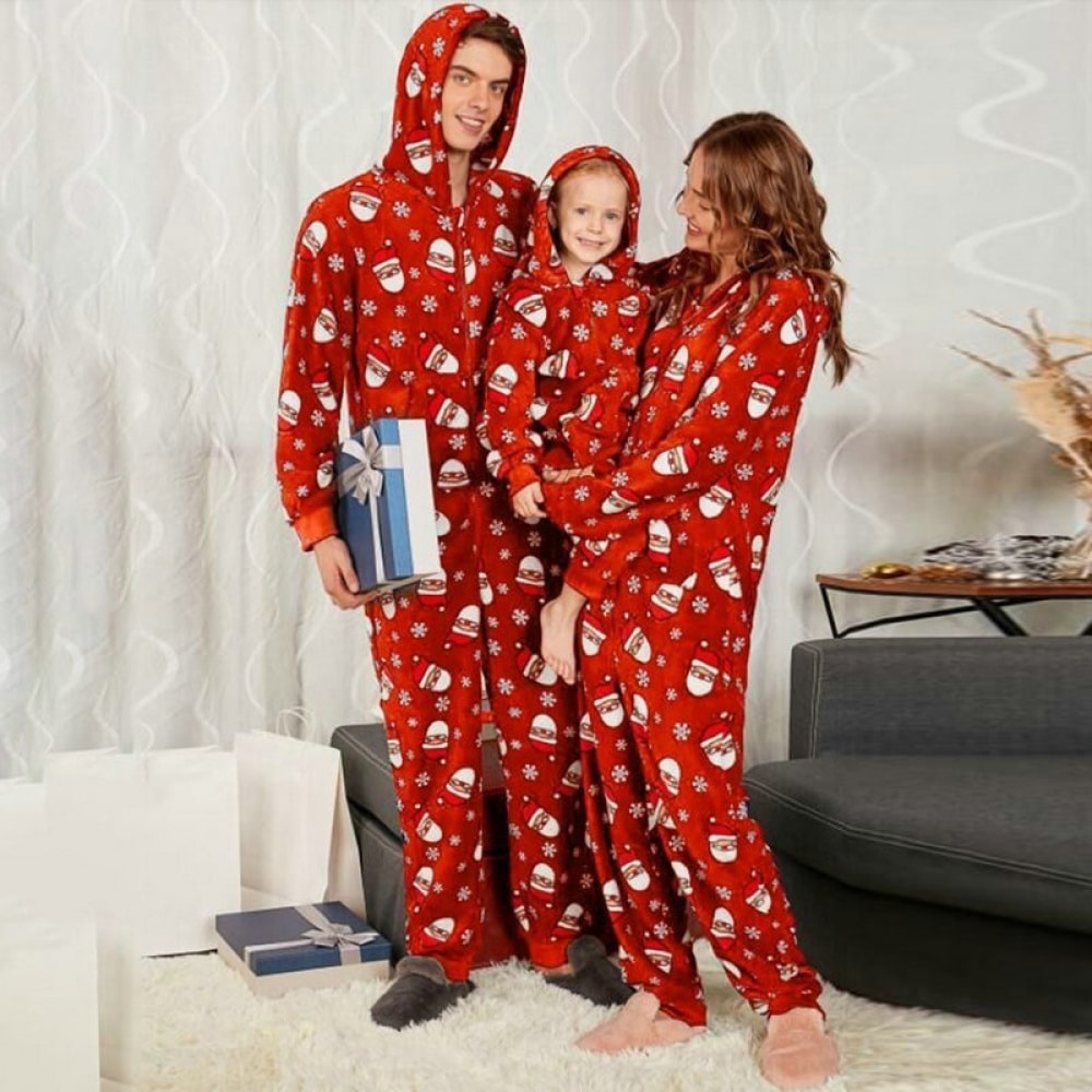 Weihnachtspyjama-Kombination mit Kapuze für die ganze Familie, getragen von einer Familie vor einem Sofa in einem Haus