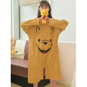 Weite Winnie Pooh Pyjamas für Frauen in Senfgelb, getragen von einer Frau vor einem Sofa in einem Haus