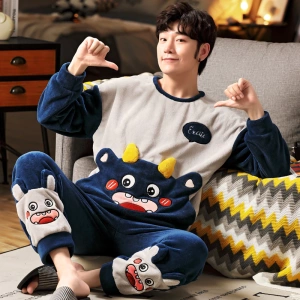 Pyjama mit freundlichen Monstern für einen Mann, der von einem Mann getragen wird, der in einem Haus auf einem Teppich sitzt
