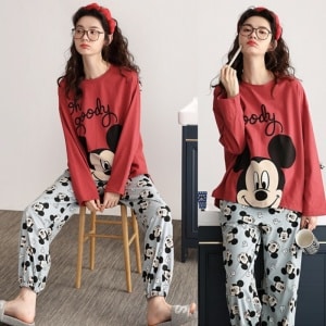 Mickey-Mouse-Pyjama-Set für Frauen, getragen von einer Frau mit einem Haarreif, die auf einem Stuhl in einem Haus sitzt