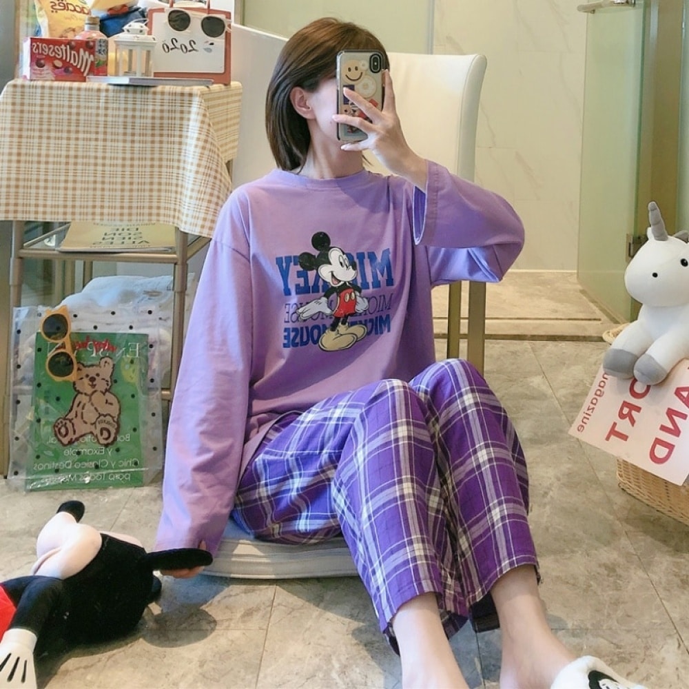 Mickey-Mouse-Pyjama mit karierter Hose für Frauen in Lila, getragen von einer Frau, die ein Foto in einem Haus macht