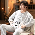 Fleece-Pyjama mit Katzenkopf für Paare, der von einem Mann getragen wird, der auf einem Stuhl in einem Haus sitzt