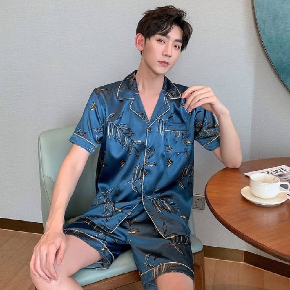 Blauer Sommerpyjama aus Seide für einen Mann, der von einem Mann getragen wird, der auf einem Stuhl in einem Haus sitzt