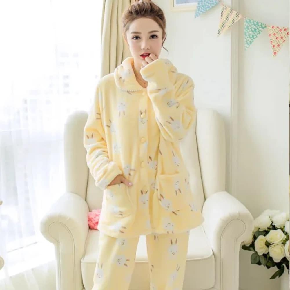Winterpyjama mit langen Ärmeln und gelbem Hasenmuster, sehr bequem von einer Frau vor einem Stuhl in einem Haus getragen