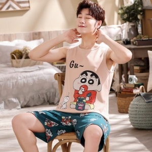Ärmelloser Sommerpyjama aus Baumwolle mit Comic-Muster für Männer, getragen von einem Mann, der auf einem Stuhl in einem Haus sitzt