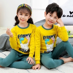 Frühlingspyjama mit gelbem Pullover und grüner Hose für Kinder mit zwei Kindern, einem Mädchen und einem Jungen, die den Pyjama tragen