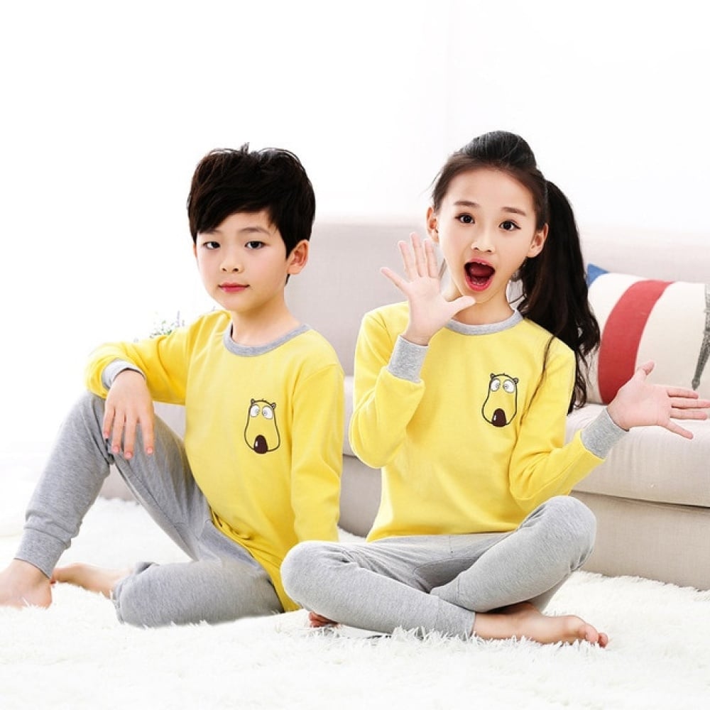 Frühlingspyjama mit gelbem Pullover und grauer Hose für Kinder mit zwei Kindern, die den Pyjama tragen