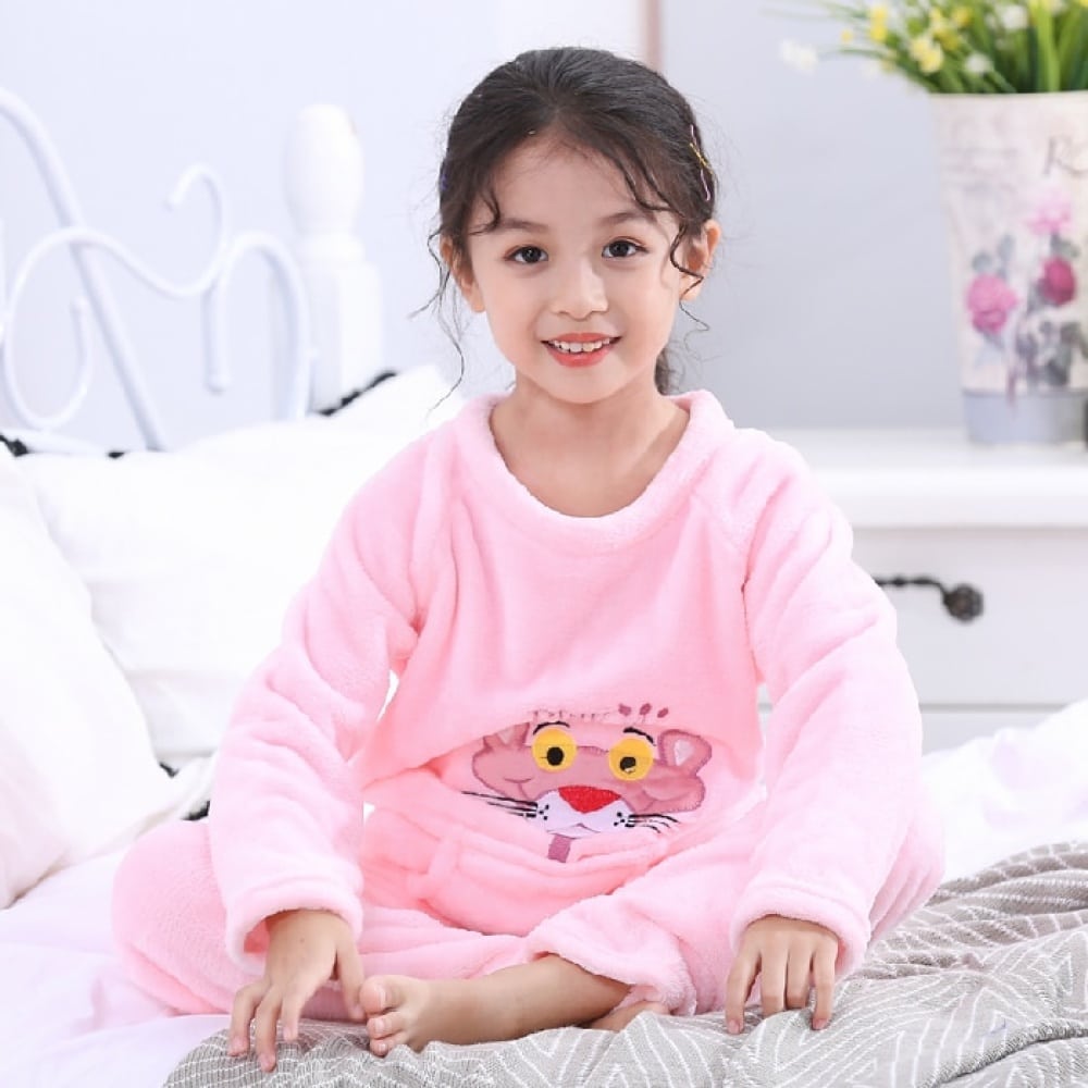 Flanellpyjama mit Pink-Panther-Aufdruck für Mädchen in Rosa, getragen von einem kleinen Mädchen auf einem Bett in einem Haus