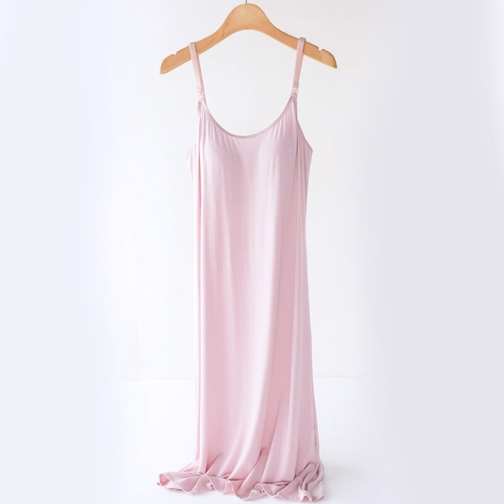 Rosa Nachthemd für Schwangerschaft und Stillzeit, auf einem hölzernen Kleiderbügel, auf weißem Hintergrund