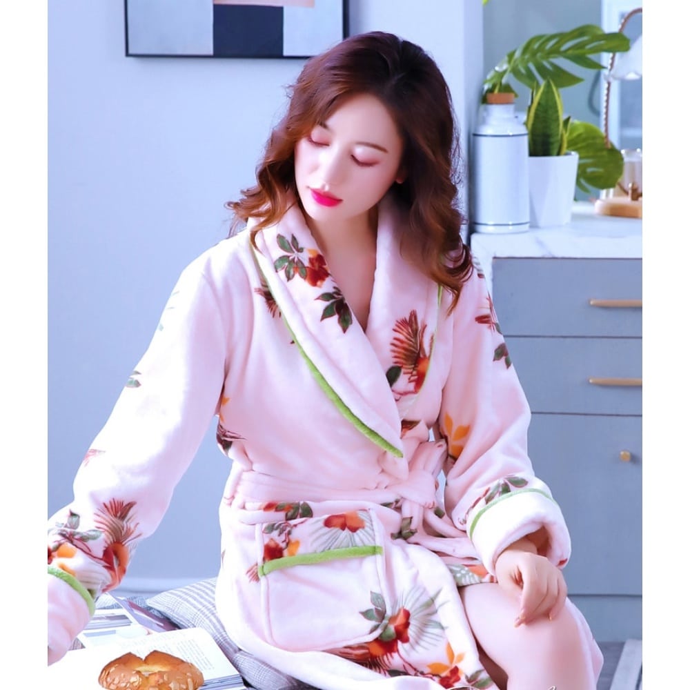 Molton-Pyjama-Bademantel mit Blumenmuster für Frauen sehr hohe Qualität, getragen von einer Frau, die auf einem Bett in einem Haus sitzt