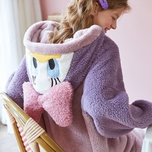 Lila und rosa Disney-Kombination mit einer lächelnden Frau, die den Pyjama trägt