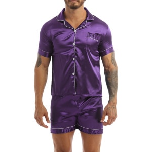 Pyjama aus violettem Satin, getragen von einem Mann mit einem Tattoo auf seinem linken Arm. Der Pyjama besteht aus Shorts und einem Hemd mit Knöpfen auf der Vorderseite