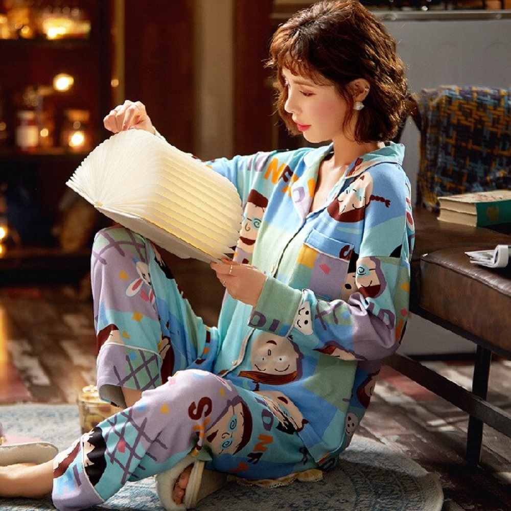 Blauer langärmeliger Frühlingspyjama mit Cartoonmuster, getragen von einer Frau, die auf einem Teppich in einem Haus sitzt