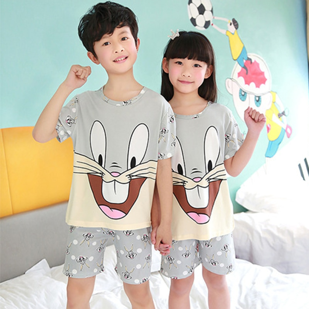 Grauer, kurzärmeliger Sommerpyjama mit Bugs Bunny-Muster für Kinder, der von Kindern in einem Haus getragen wird