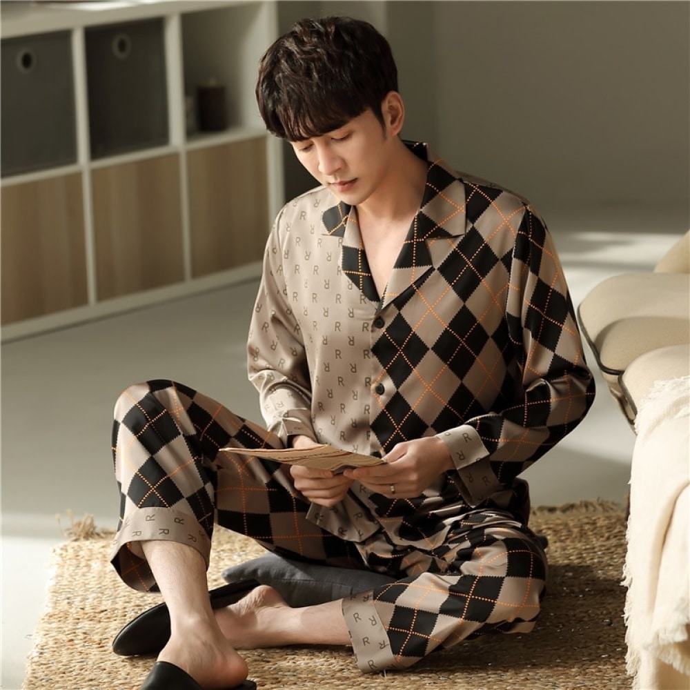 Langärmeliger Baumwollpyjama mit Umlegekragen für einen Mann, der von einem Mann getragen wird, der auf einem Teppich in einem Schlafzimmer sitzt