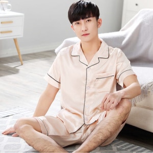 Kurzärmeliger Satinpyjama mit Umlegekragen für Männer mit einem Mann, der den Pyjama auf dem Sofa trägt