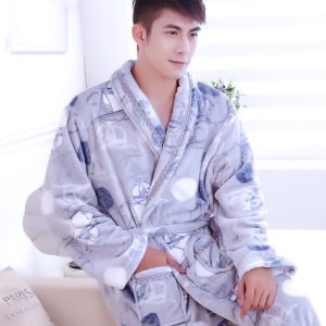 Pyjama-Bademantel aus Flanell mit Bootsmuster für einen Mann, der von einem Mann getragen wird, der auf einem Stuhl sitzt