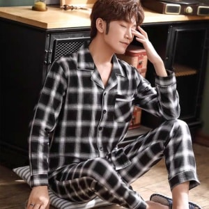 Langärmeliger karierter Pyjama für Männer mit einem Mann, der den Pyjama trägt, mit einem Hintergrund einer Küche