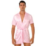 stehender dunkelhaariger Mann, der einen rosafarbenen Kimono-Pyjama aus Satin trägt, der mit einem Gürtel in der Taille gebunden ist