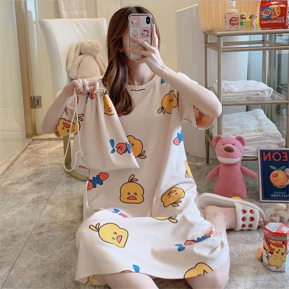 Pyjama-Nachtkleid mit Cartoon-Druck für Frauen, das von einer Frau getragen wird, die auf einem Teppich in einem Haus sitzt