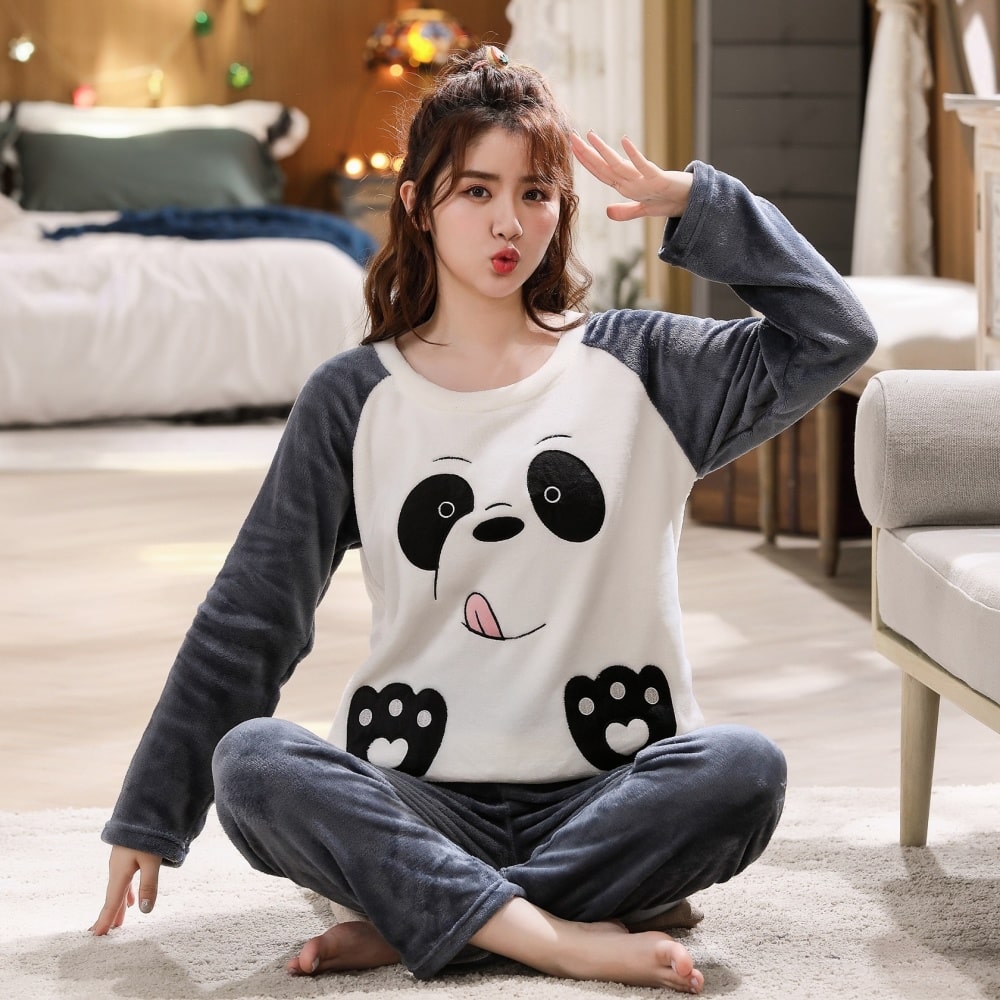 Blau-weißer Unisex-Fleece-Pyjama mit Pandakopf, getragen von einer lächelnden jungen Frau