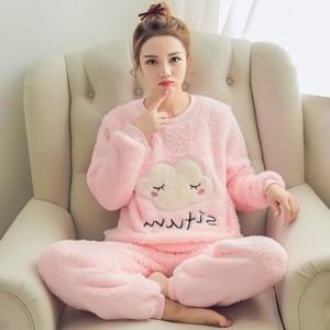 Warmer Fleece-Pyjama rosa Wolke mit einer Frau, die den Pyjama auf dem Sofa trägt