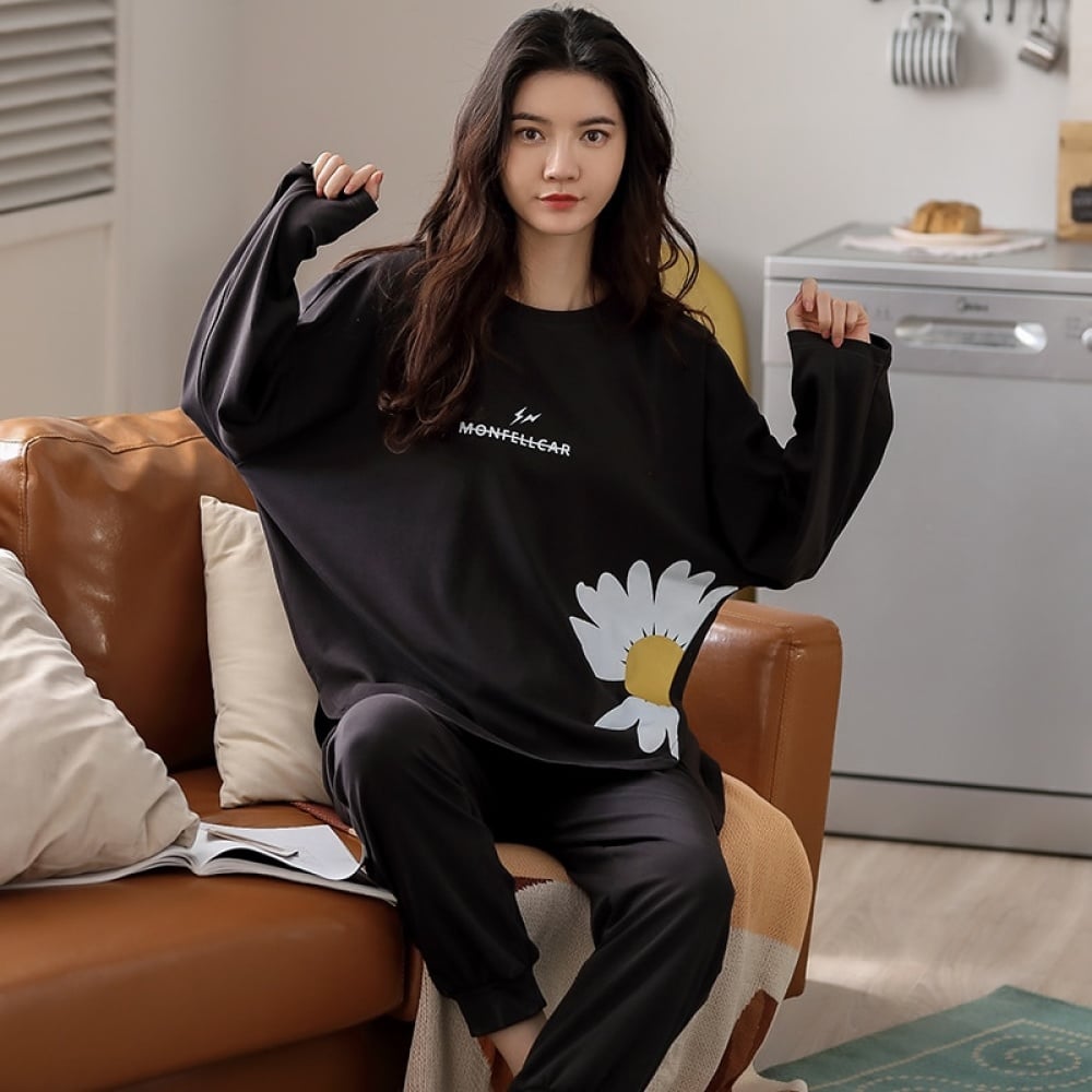 Winterpyjama für Frauen aus schwarzem Satin mit einer Frau, die den Pyjama auf dem Sofa schützt