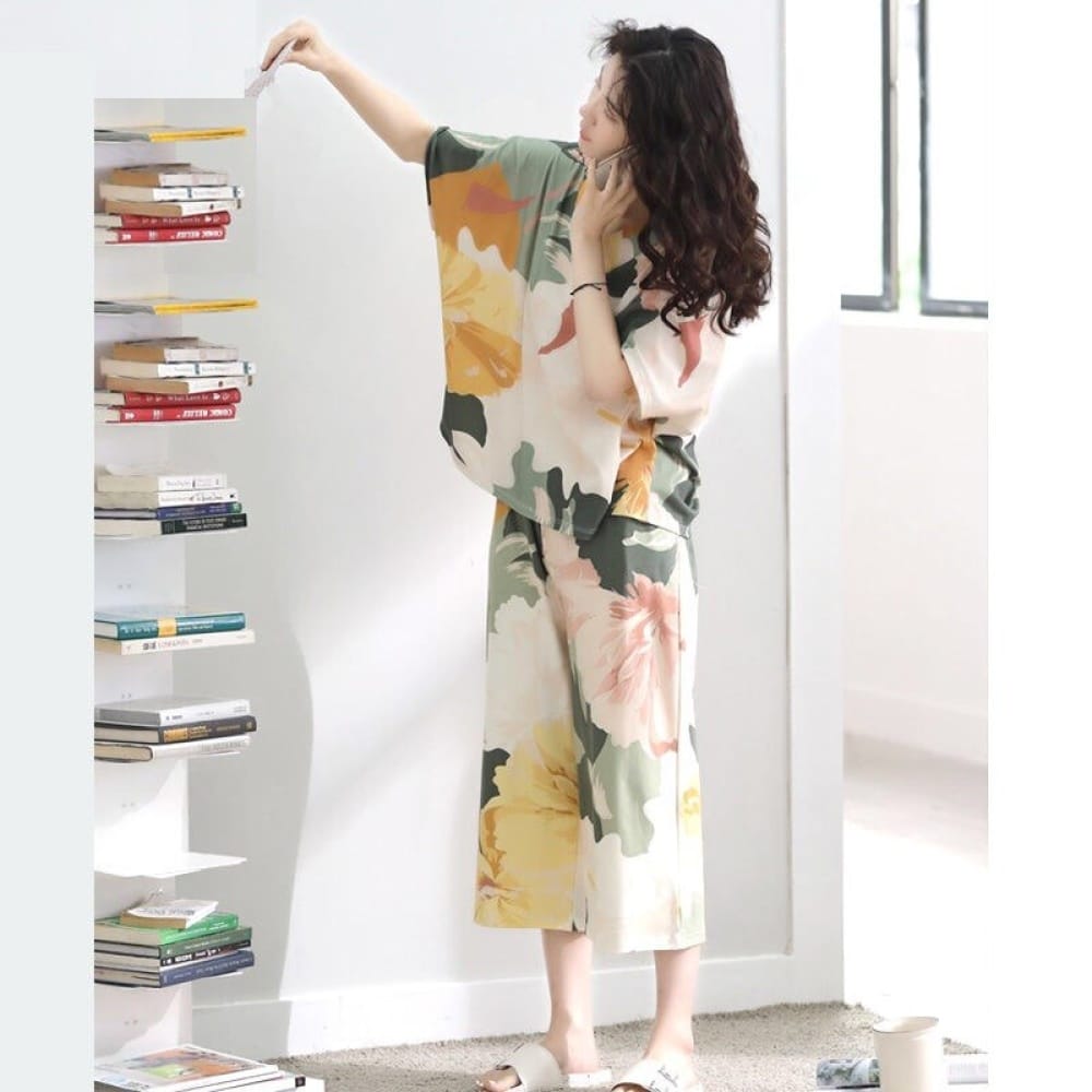 Sommerpyjama mit Fledermausärmeln und Blumenmuster, getragen von einer Frau, die in einem Haus ein Buch las