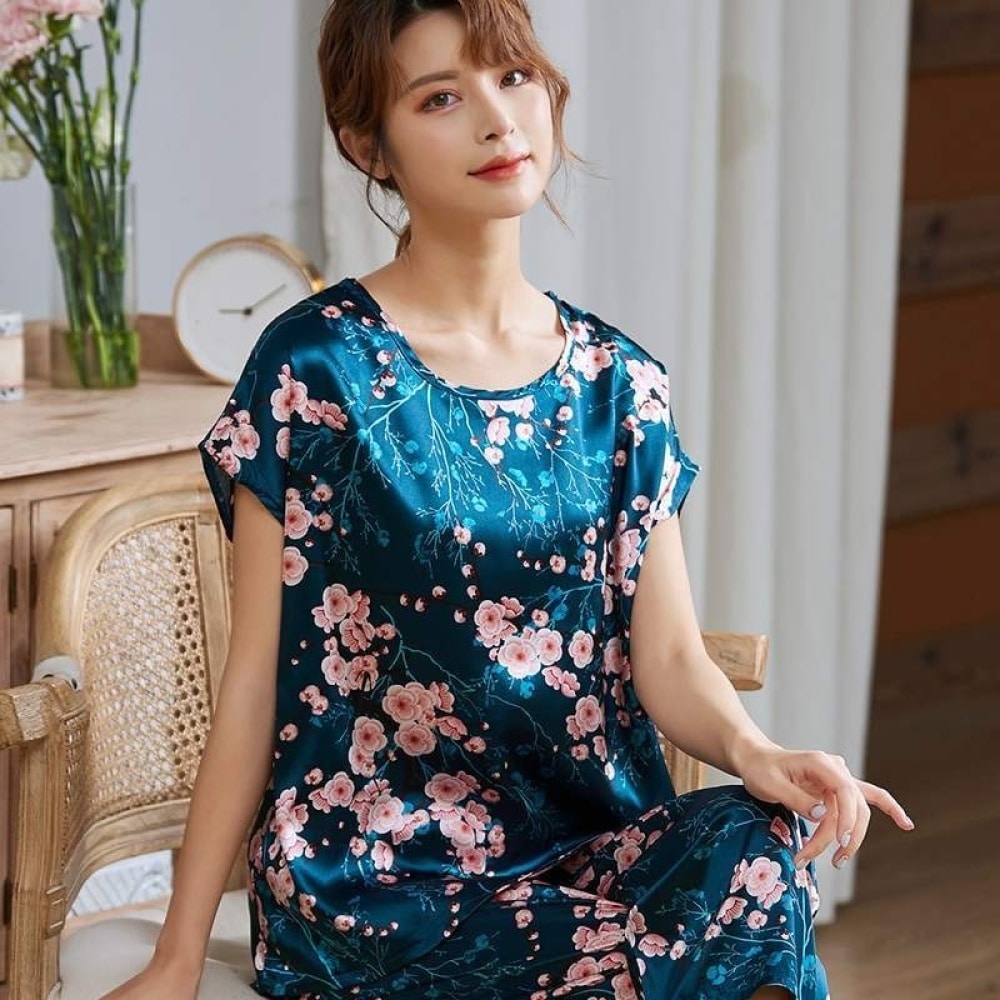 Zweiteiliger Sommerpyjama aus Seidensatin für Frauen, die auf einem Stuhl in einem Haus sitzen