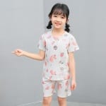 Zweiteiliger weißer Pyjama mit Cartoon-Motiv für kleine Mädchen mit einem kleinen Mädchen, das den Pyjama trägt, und einem grauen Hintergrund