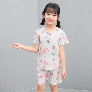 Zweiteiliger weißer Pyjama mit Cartoon-Motiv für kleine Mädchen mit einem kleinen Mädchen, das den Pyjama trägt, und einem grauen Hintergrund
