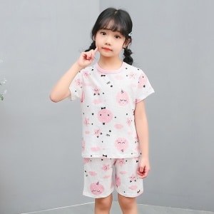 Zweiteiliger weißer Pyjama mit Cartoon-Aufdruck für kleine Mädchen mit einem Mädchen, das den Pyjama trägt